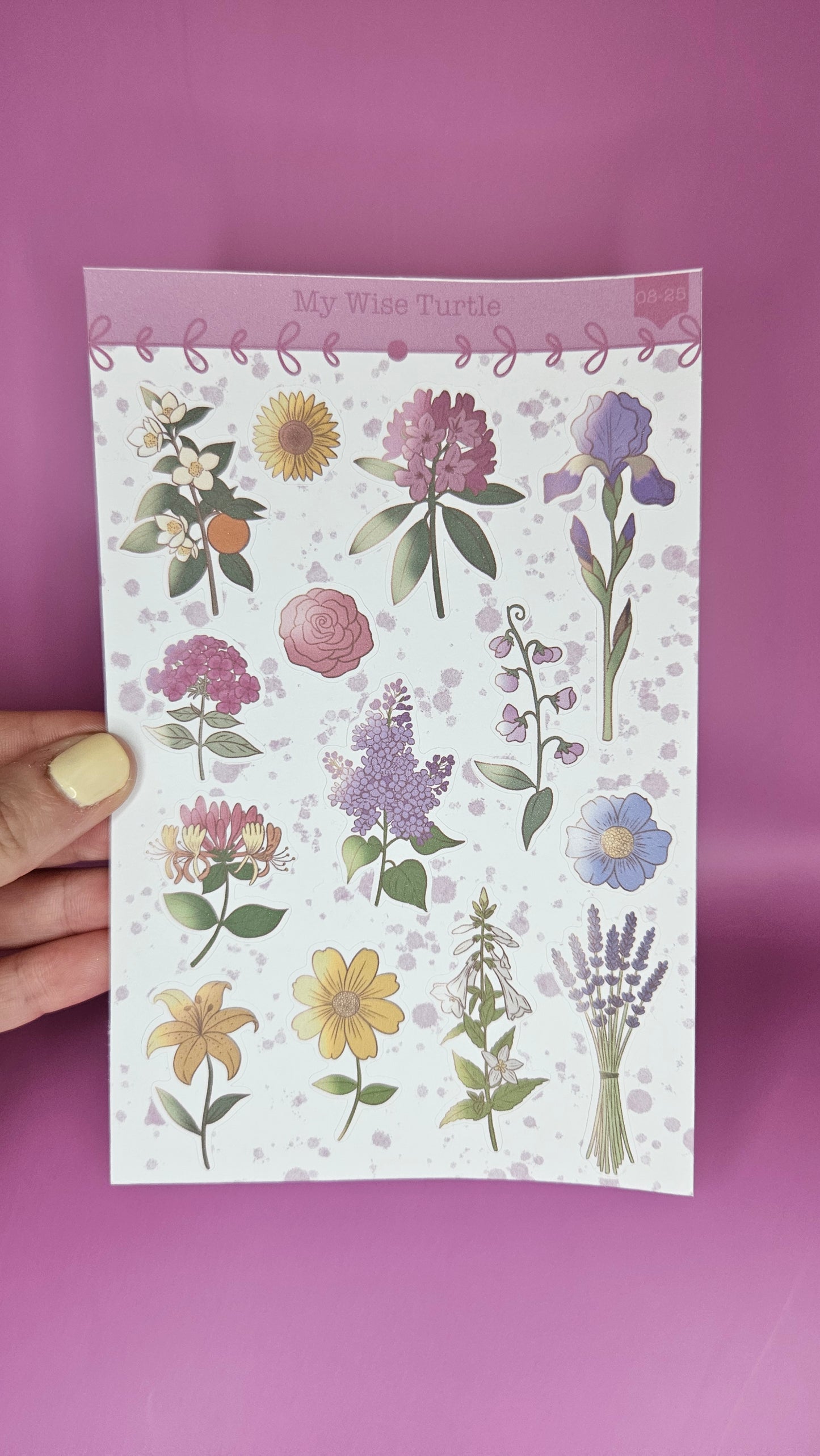 Floral notebook held by a hand on a purple background