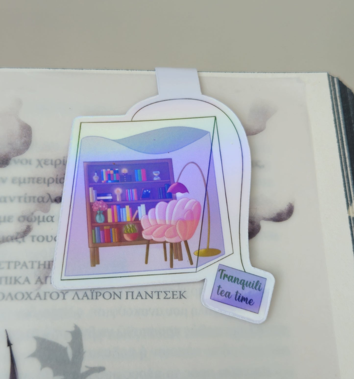 Holographic sticker with a 'Tranquil tea time' design on a book page.