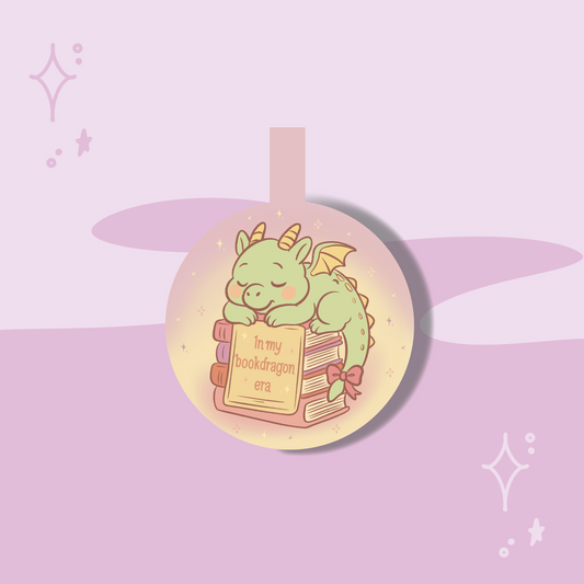 Circular pendant with a green dragon illustration and text on a pink and purple gradient background